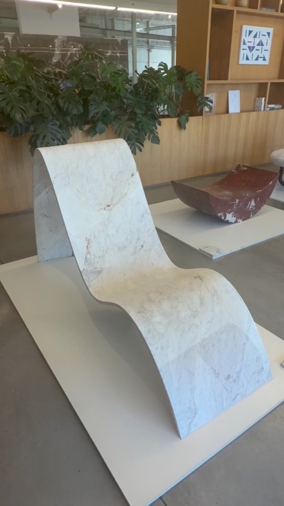 Chaise longue esculpida em mármore claro em showroom de design